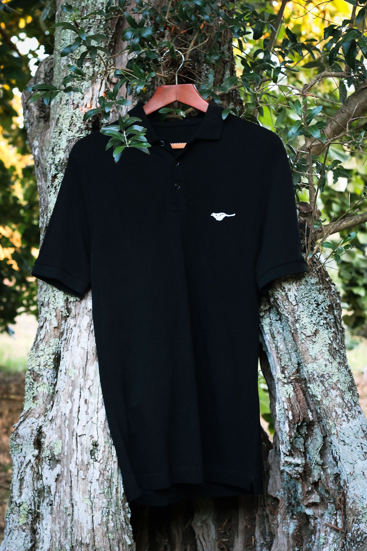 picth-black-biodegradable-pure-merino-wool-golf-polo-shirt-for men-by-snöleo.-hanging-in-olive-tree