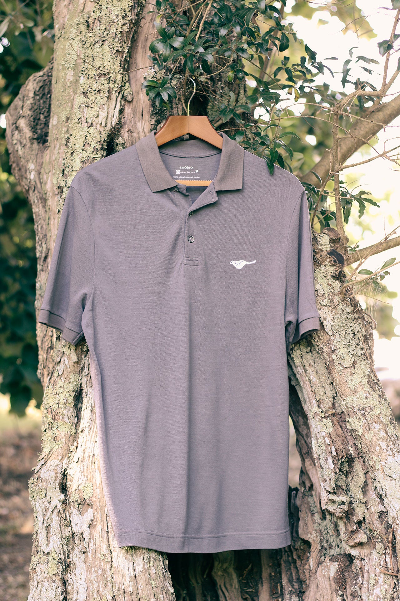 granite-grey-biodegradable-pure-merino-wool-golf-polo-shirt-for men-by-snöleo.-hanging-in-olive-tree